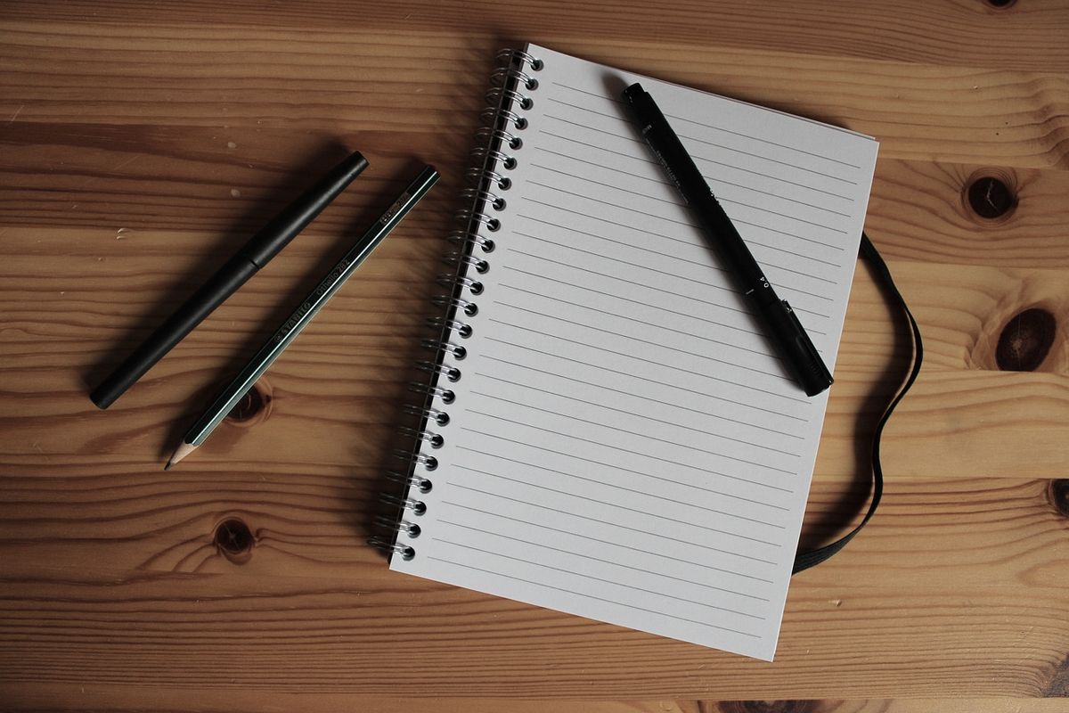 A stack of course notes and a notebook on a clean work surface